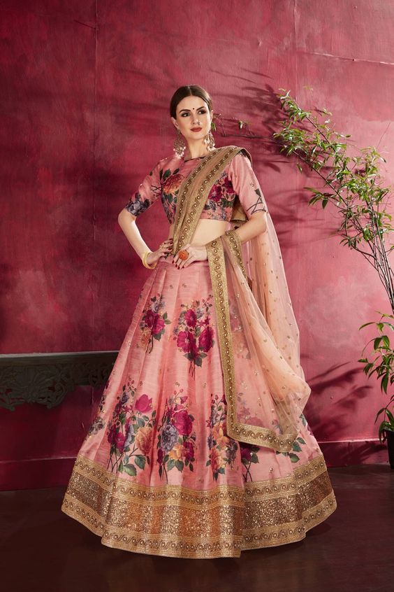 image of peach lehenga with pink floral prints and golden broad border on it 